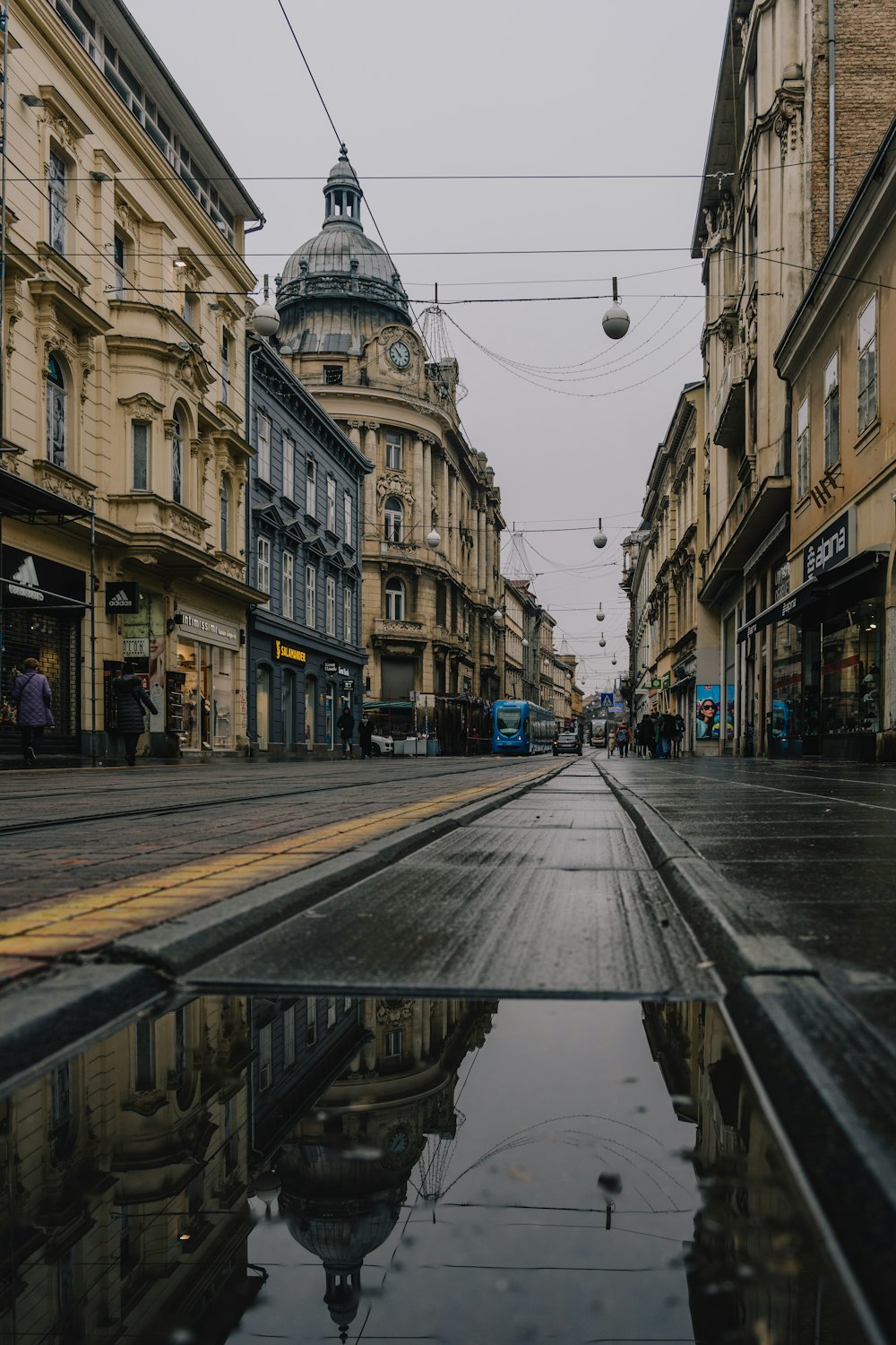 a city street with a puddle of water in the middle of it