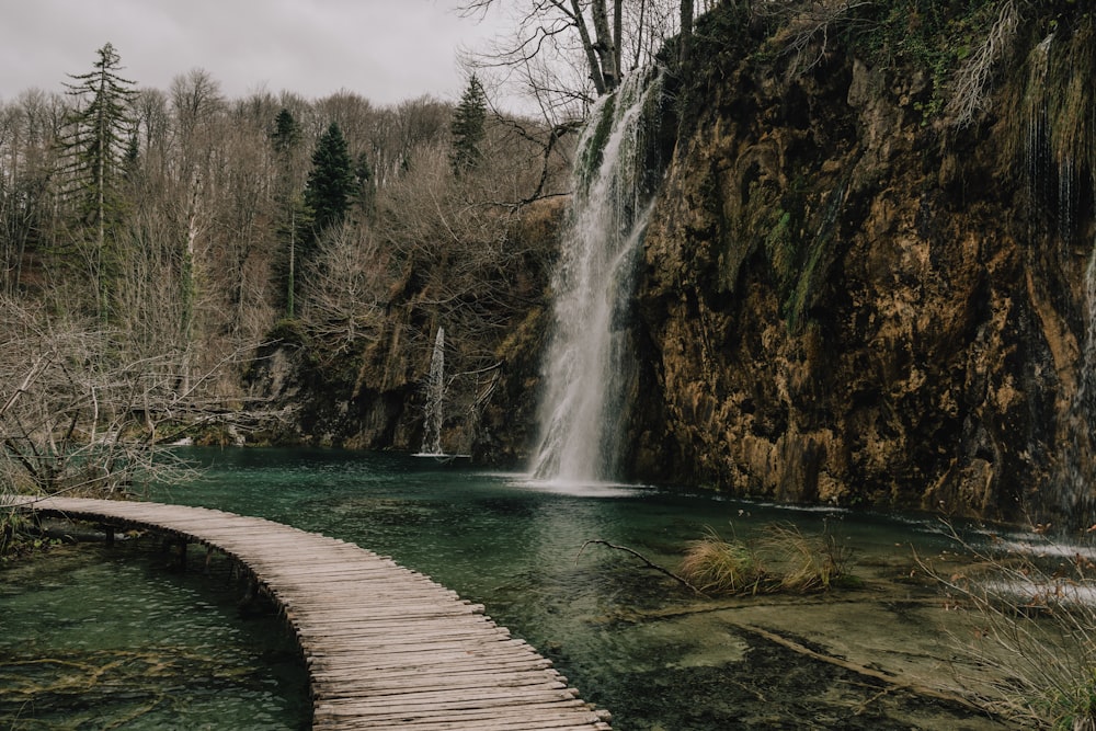 a wooden walkway leading to a waterfall