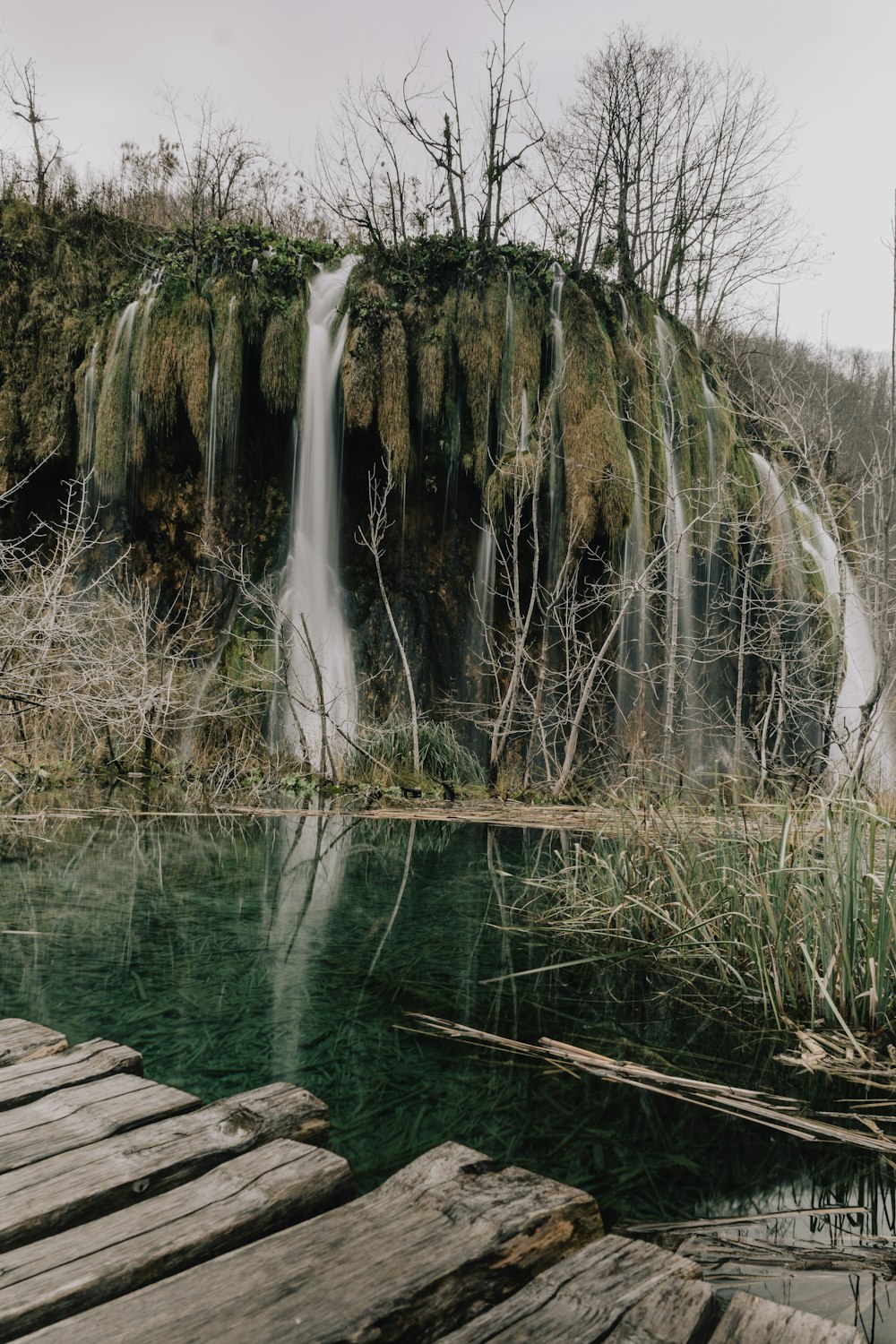 a wooden dock sitting in front of a waterfall