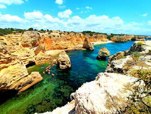 Adventurers kayaking on crystal-clear turquoise waters surrounded by cliffs