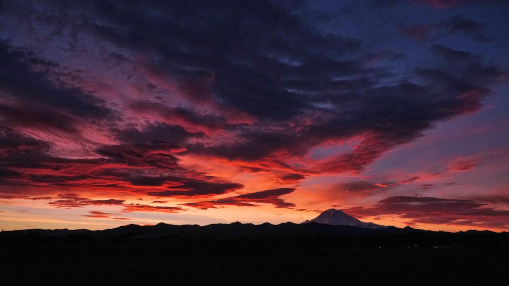 a sunset with a mountain in the background