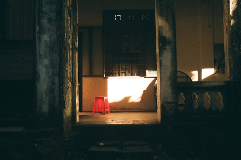 a red trash can sitting in the doorway of a building