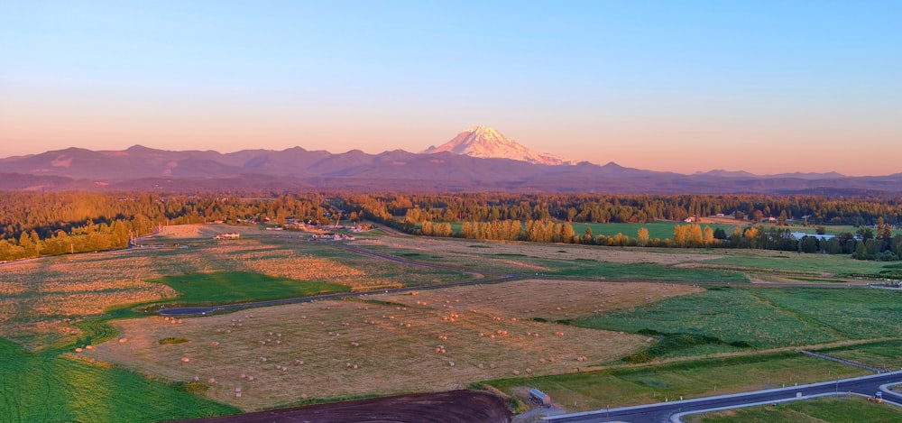 an aerial view of a mountain range with a road in the foreground