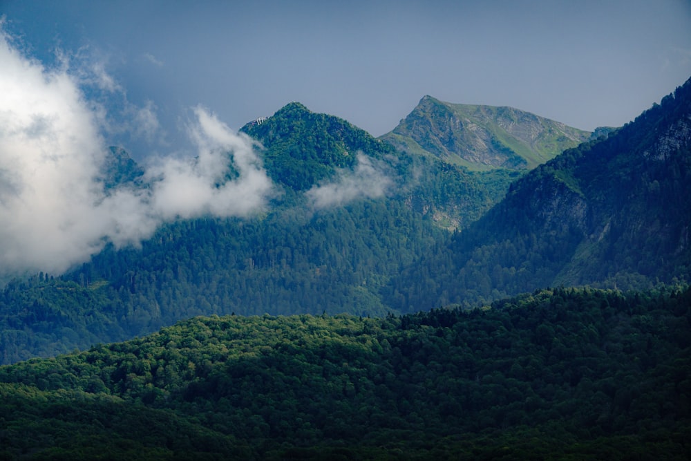 a view of a mountain range with trees and clouds