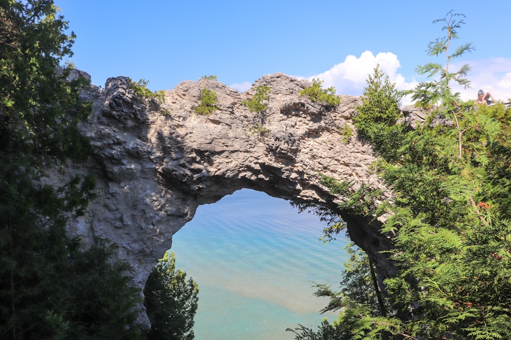 a view of the water through an arch in a cliff