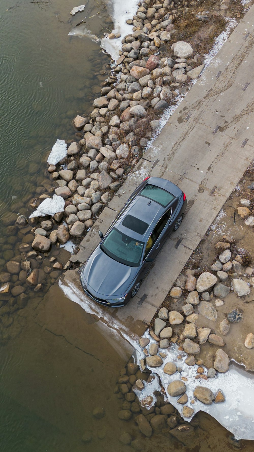 a car parked on the side of a road next to a body of water