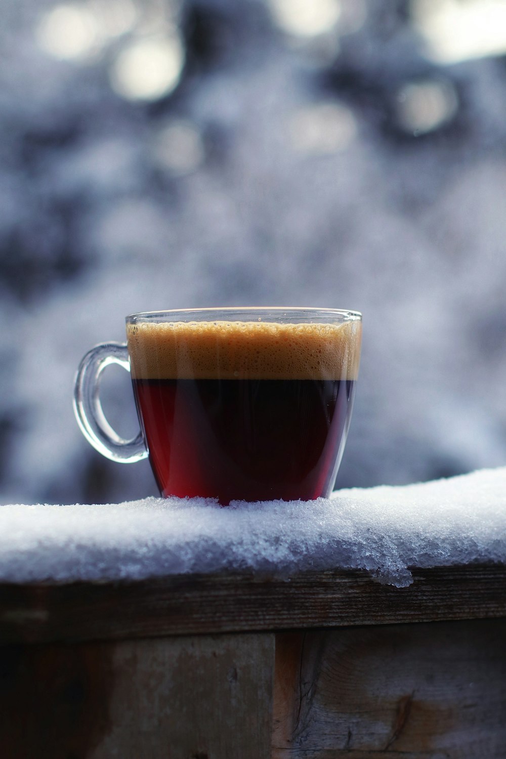 a cup of coffee sitting on top of a wooden table