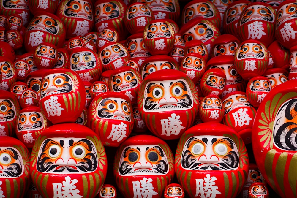 a large group of red and white dolls with asian writing on them