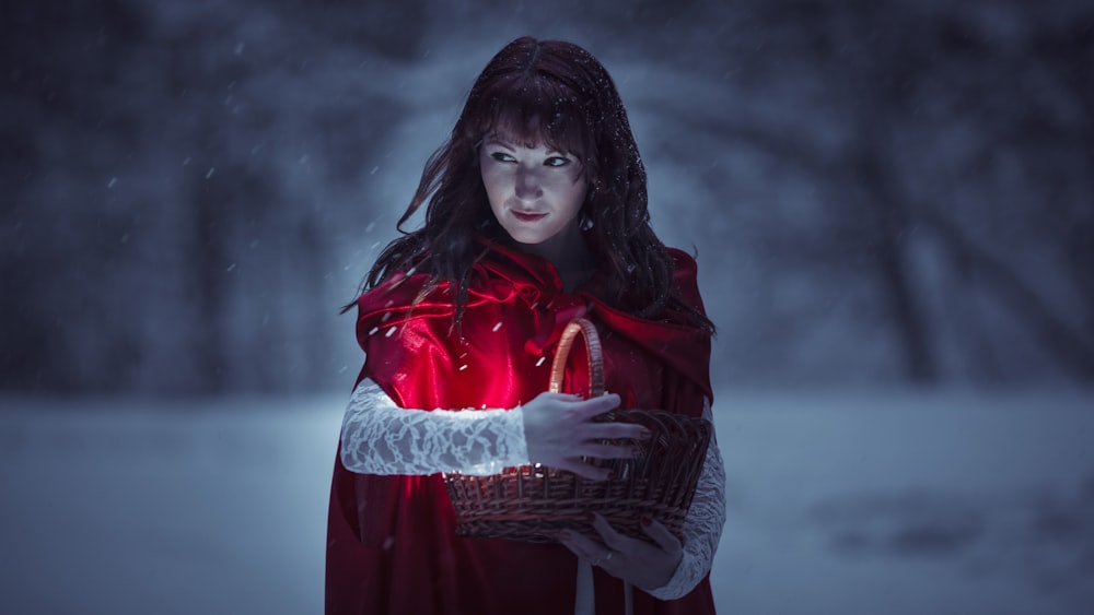 a woman in a red cape holding a basket