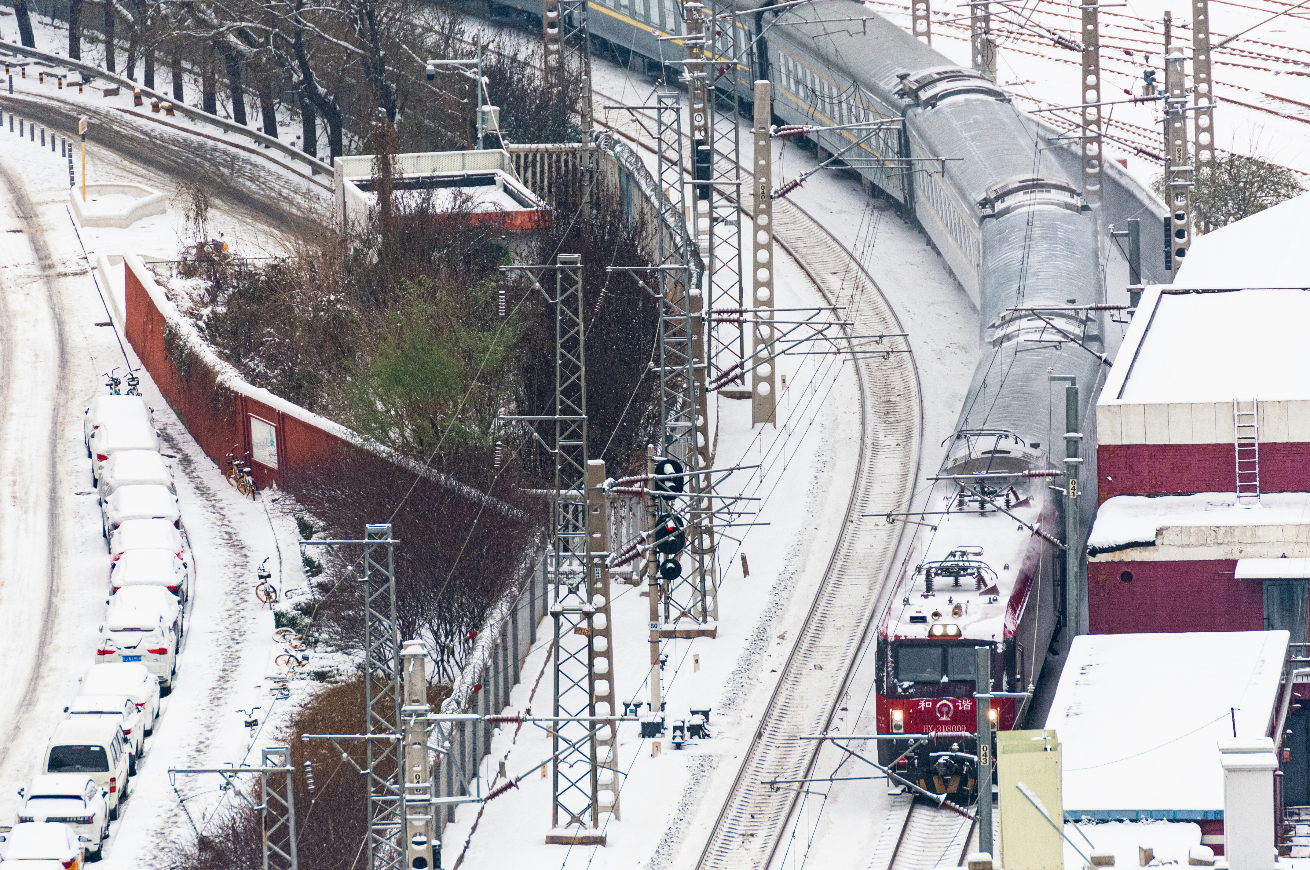 a train traveling down tracks next to a snow covered hillside