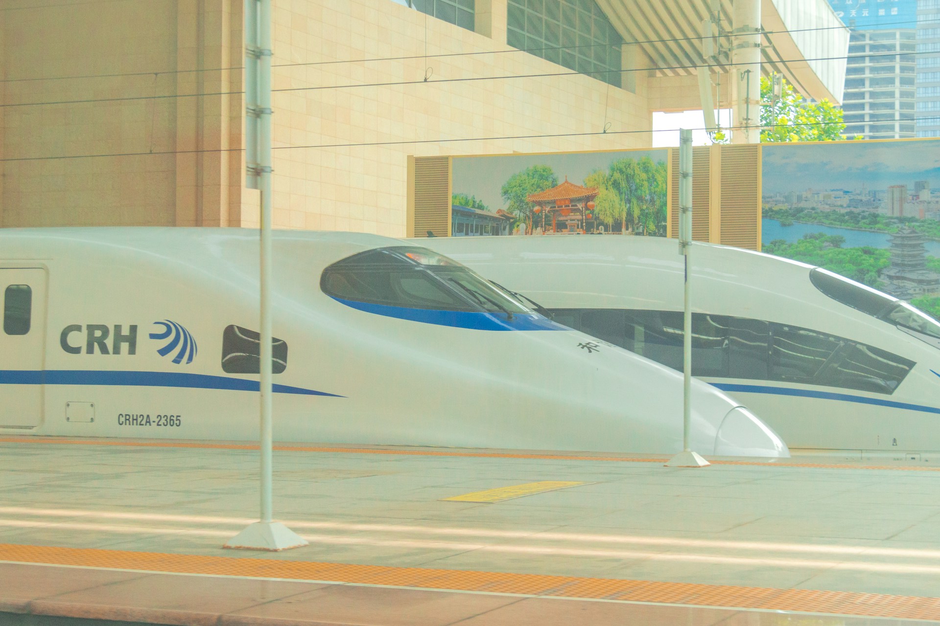 a white and blue bullet train parked in front of a building