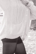 A close-up of a soft grey cardigan draped over a stylish blouse, displaying its texture.