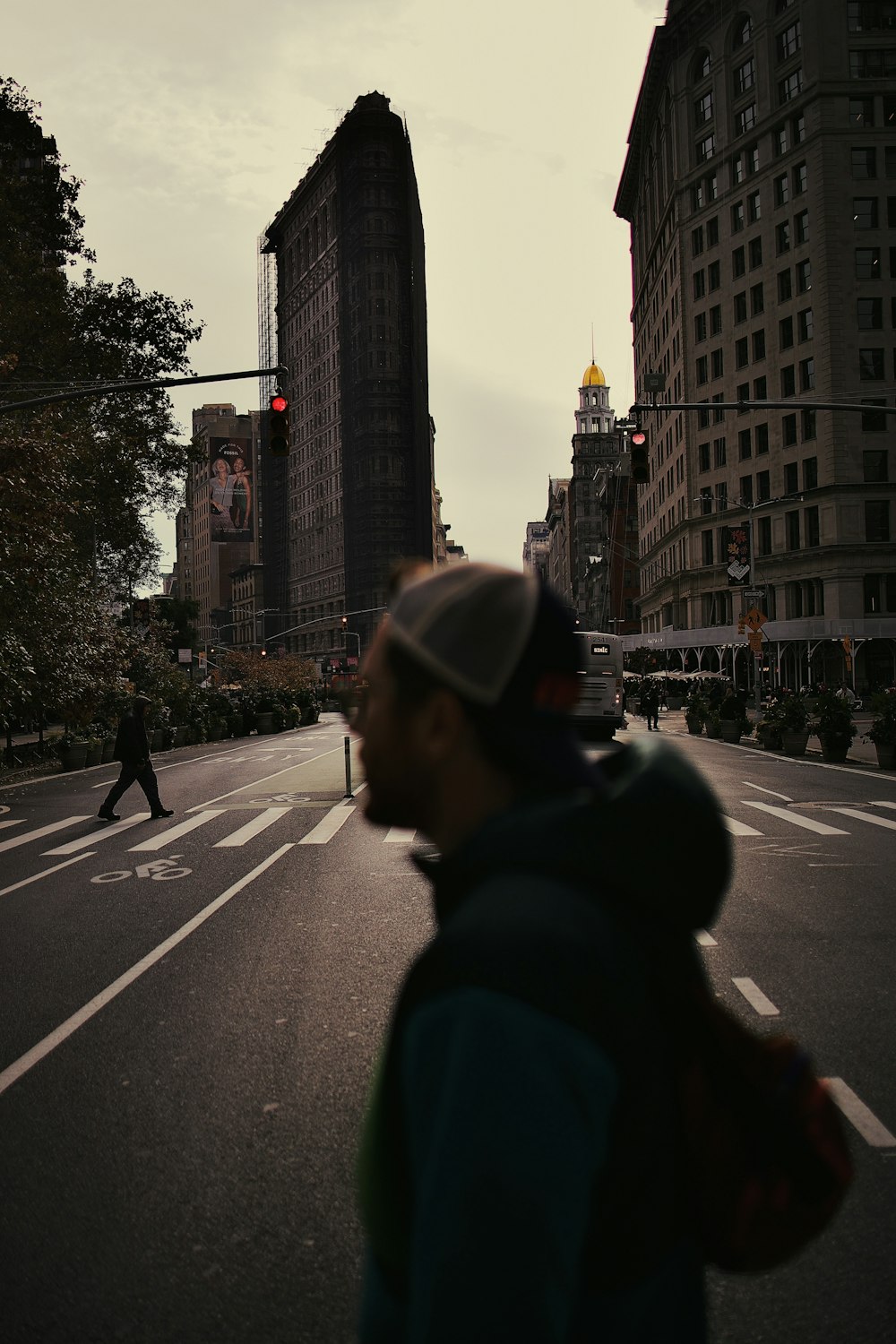 a man walking across a street next to tall buildings