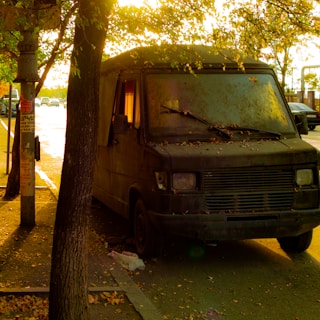 A rugged, well-used van parked on a quiet street at sunset, ready for a move.