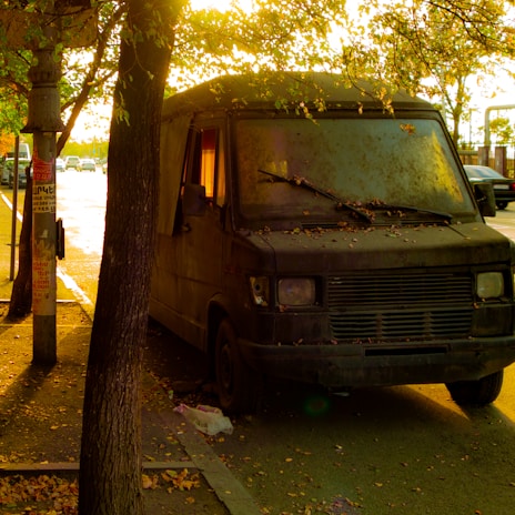 A rugged, well-used van parked on a quiet street at sunset, ready for a move.