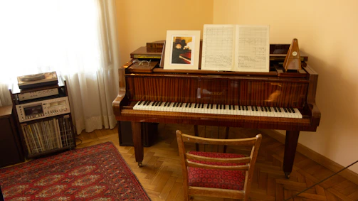 Ethan confidently testing piano pitch with a tuning fork in a cozy, upscale music room.
