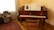 A cozy music room with a piano and warm lighting in Villa Musica Ahrensburg.