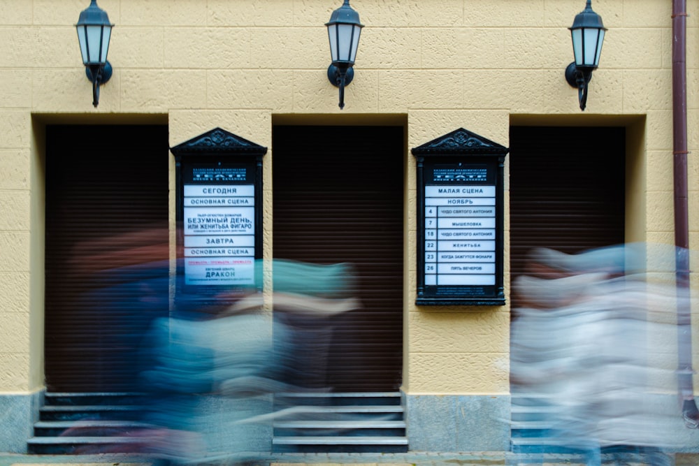 a blurry photo of people walking past a building