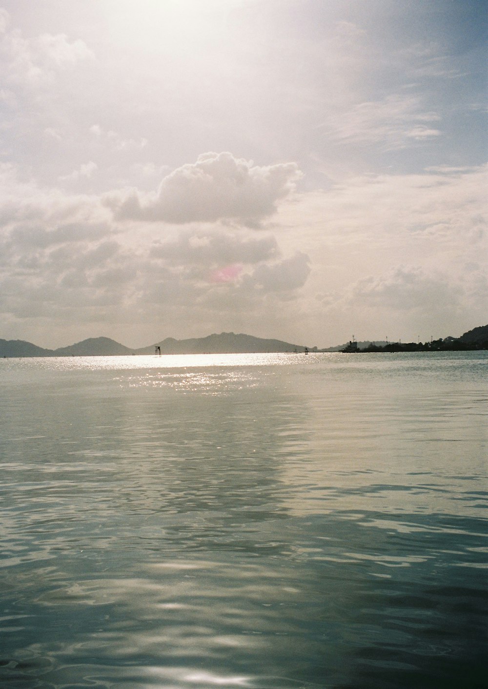 a large body of water with a boat in the distance