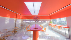 Modern interior of Sabor Llanero with black, white, and orange accents and a friendly takeout counter.
