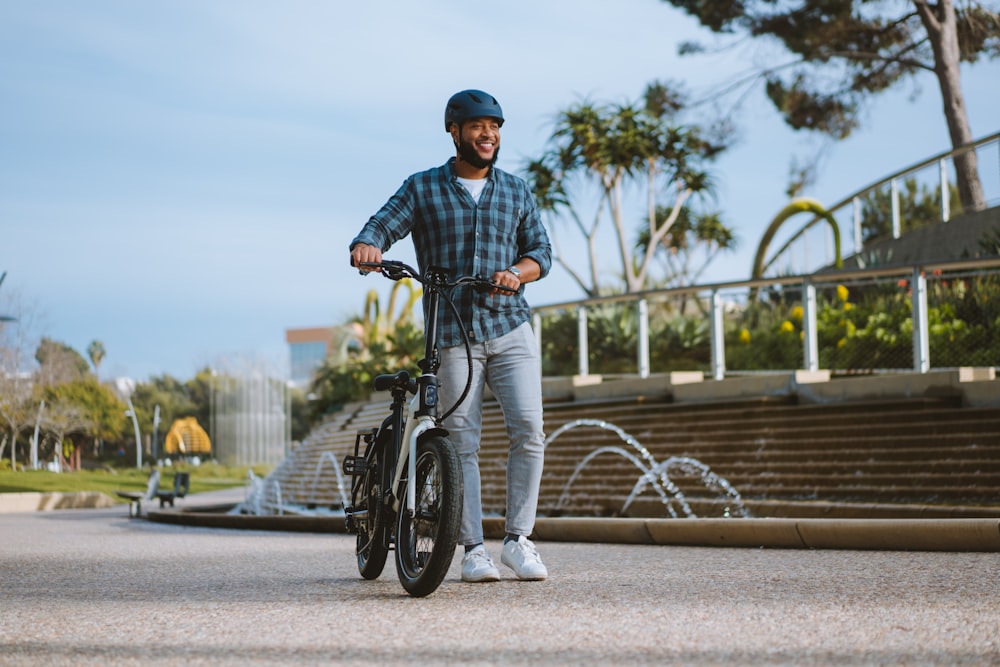 a man riding a bike down a street next to a fountain