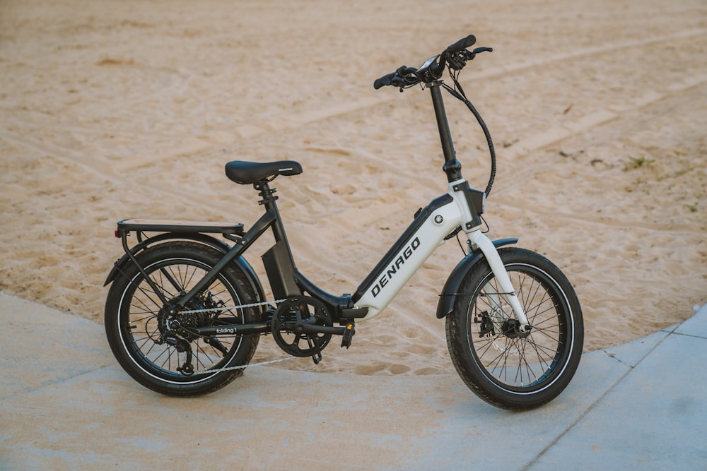 an electric bike parked on a sidewalk in the sand