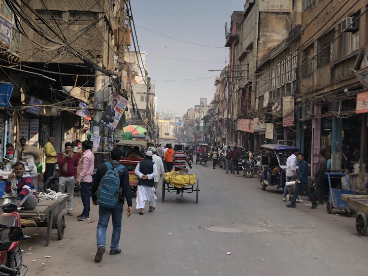 A vibrant street scene in Bihar showing local vendors and commuters under a bright morning sky.