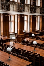 a room filled with lots of wooden tables and chairs