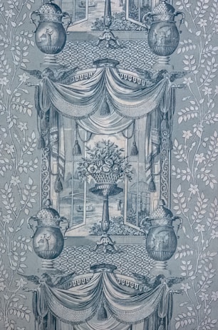 A detailed and intricate wallpaper pattern with symmetrical design elements. Two large urns feature decorative patterns and are flanked by stylized foliage. A central vase holds an ornate bouquet of flowers, framed by draped fabric and tassels. The background displays lattice patterns, and scenes reminiscent of classical art appear within the frames.
