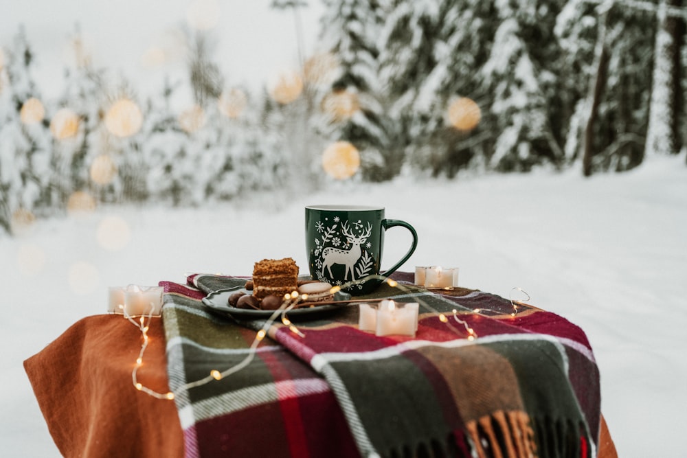 a plaid blanket with a cup of coffee on it