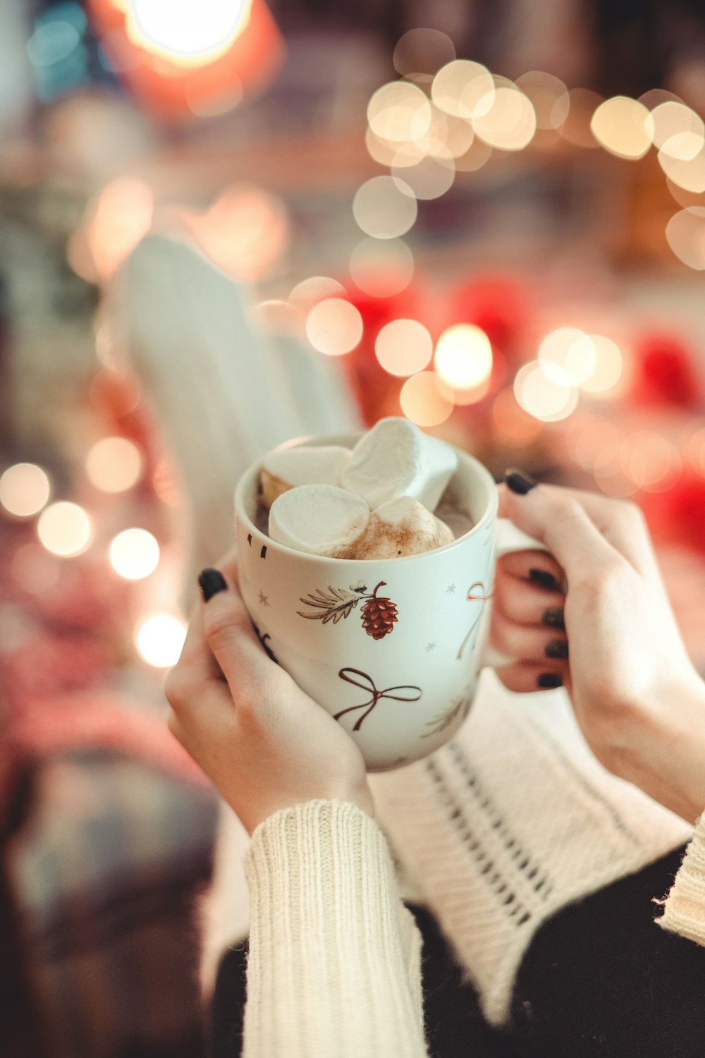 a woman holding a cup of hot chocolate
