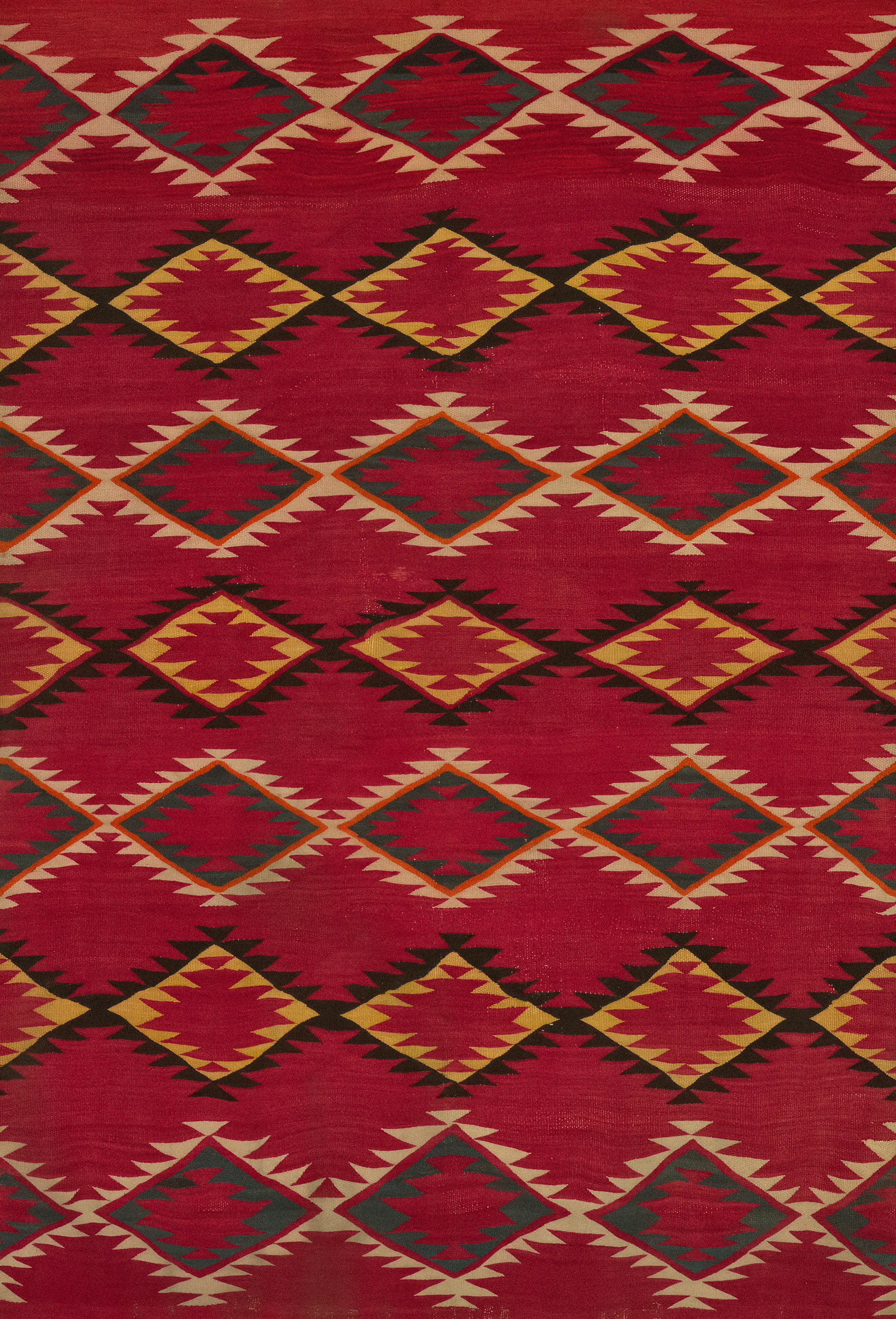 a red and yellow rug with a diamond pattern