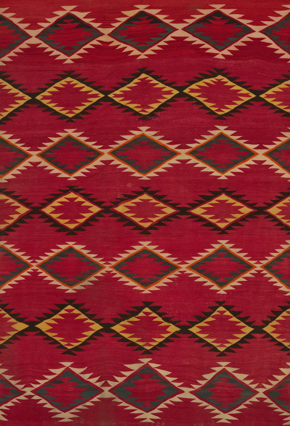 a red and yellow rug with a diamond pattern