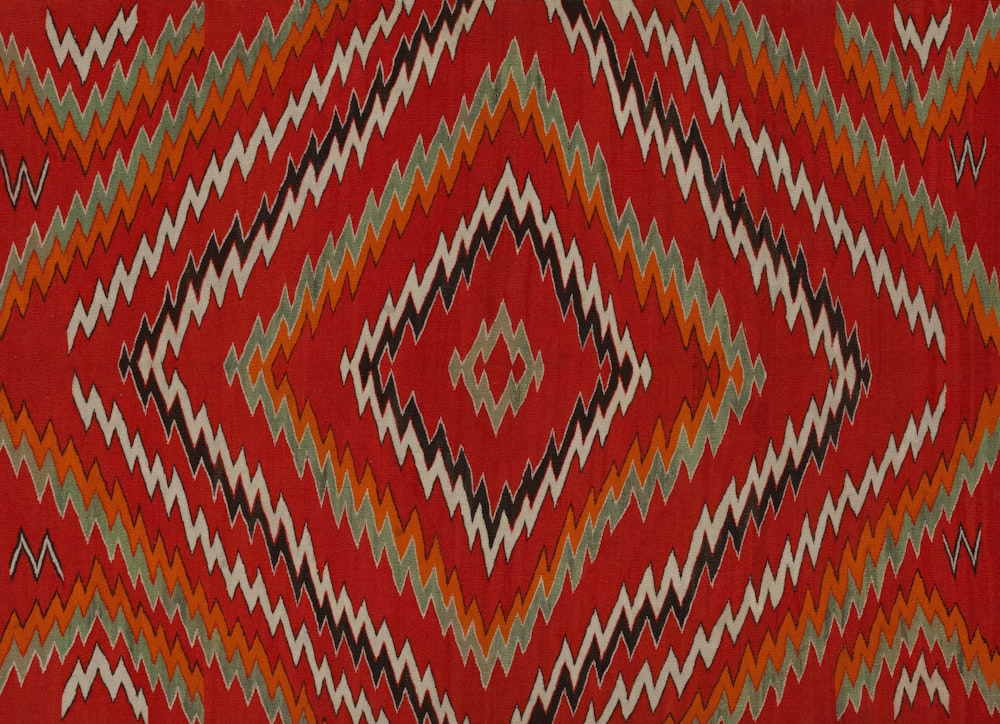 a red rug with a diamond pattern on it