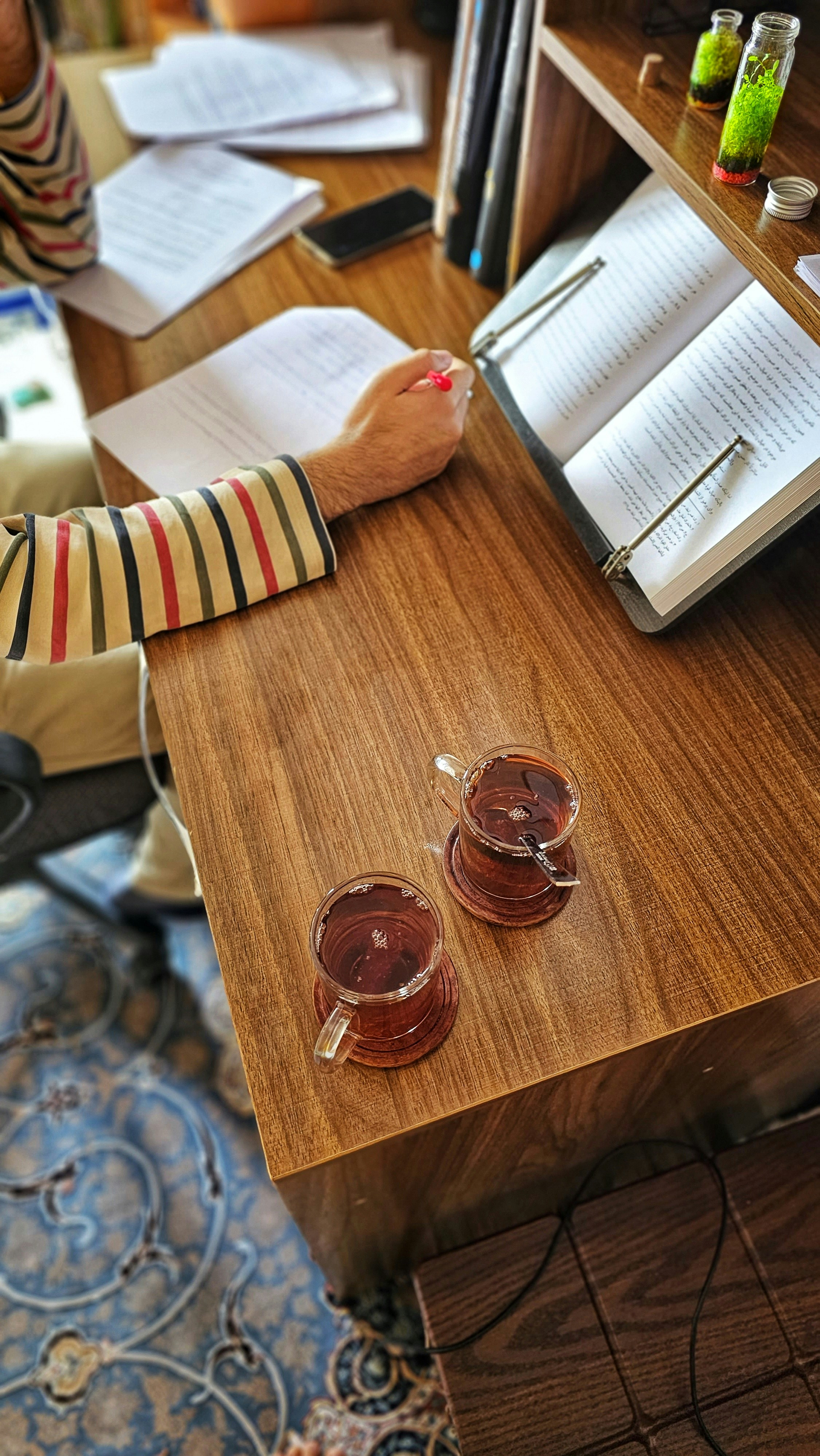 Student studying with books and notes on a wooden desk