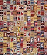 A vibrant quilt made from colorful company shirts, each square representing a different employee's journey.