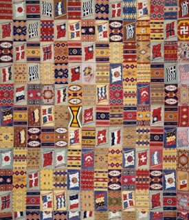 Brightly dyed fabric pieces arranged in a patchwork quilt showcasing traditional motifs