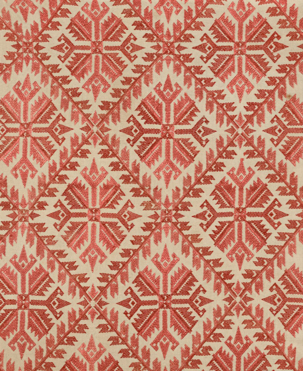 a red and white rug with a pattern on it