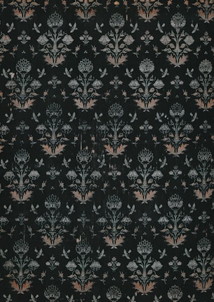 A dark, intricately patterned wallpaper featuring symmetrical floral designs. The repeating motifs include stylized flowers and leaves, along with subtle butterfly shapes, all rendered in muted shades of green, white, and orange.