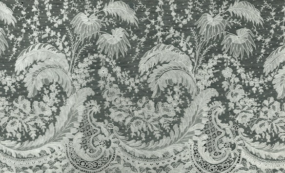 Intricate floral and paisley patterns are woven into the fabric with delicate lace detailing. Leaves and flowers are prominently featured, with intricate lines adding depth and texture.