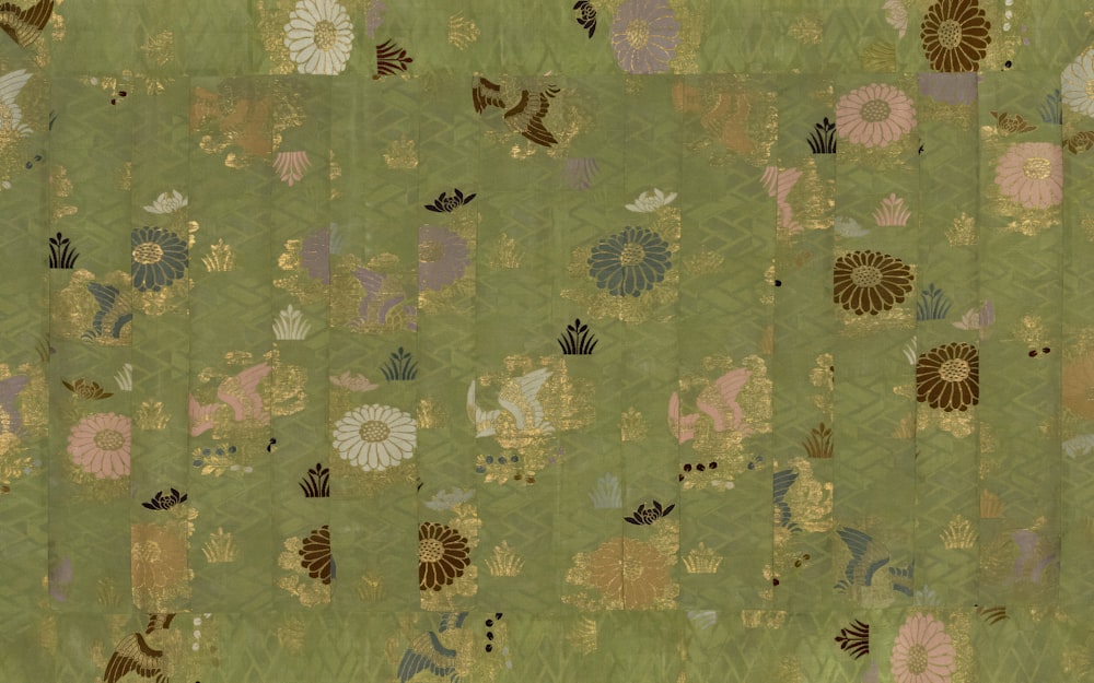 a patchwork quilt with animals and flowers on a green background