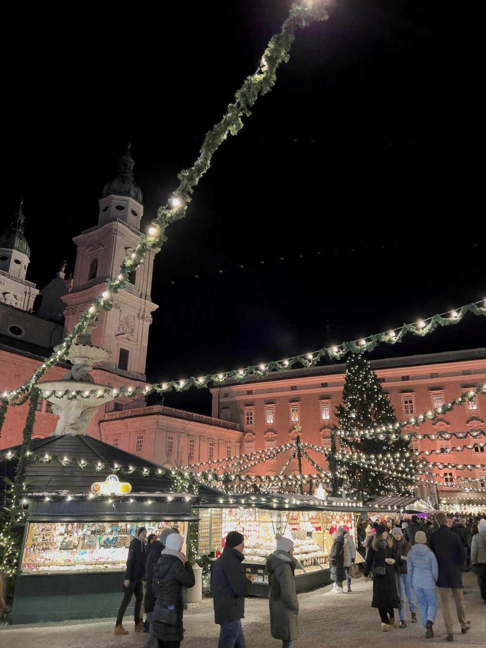 a group of people standing around a christmas tree