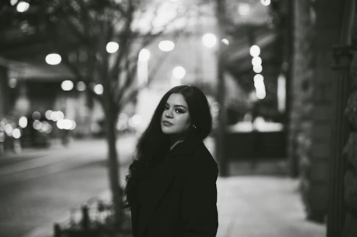 A photographer capturing a candid portrait of a woman in an urban setting.