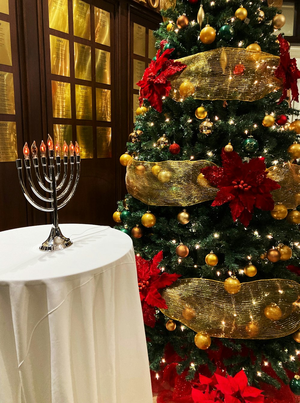 a christmas tree with a lit menorah next to it