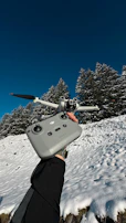 A vibrant shot of a drone controller held against a clear blue sky.