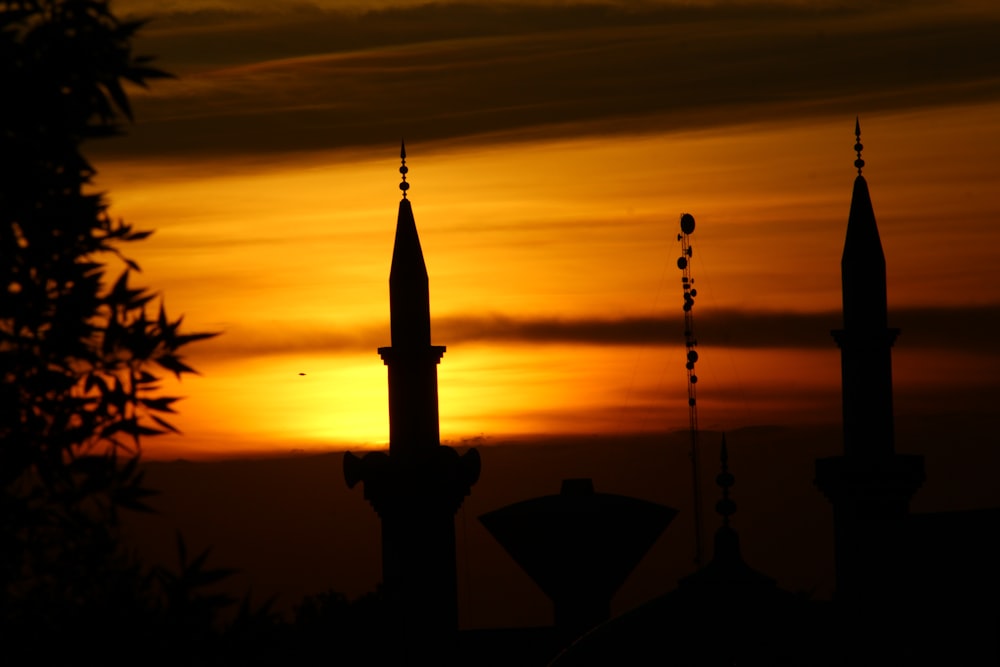 the sun is setting behind a silhouette of a building