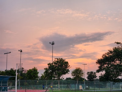 Evening scene of the sports hub lit up with players enjoying a friendly match.