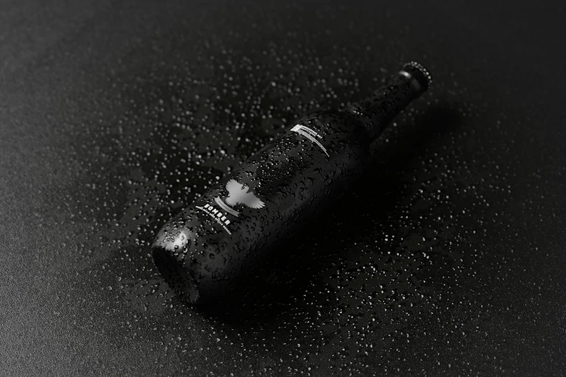 A sleek neon-lit bottle of cold beer with condensation droplets glowing against a dark urban backdrop.