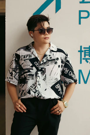 A stylish young person wearing music-inspired accessories and a graphic tee, posing confidently.