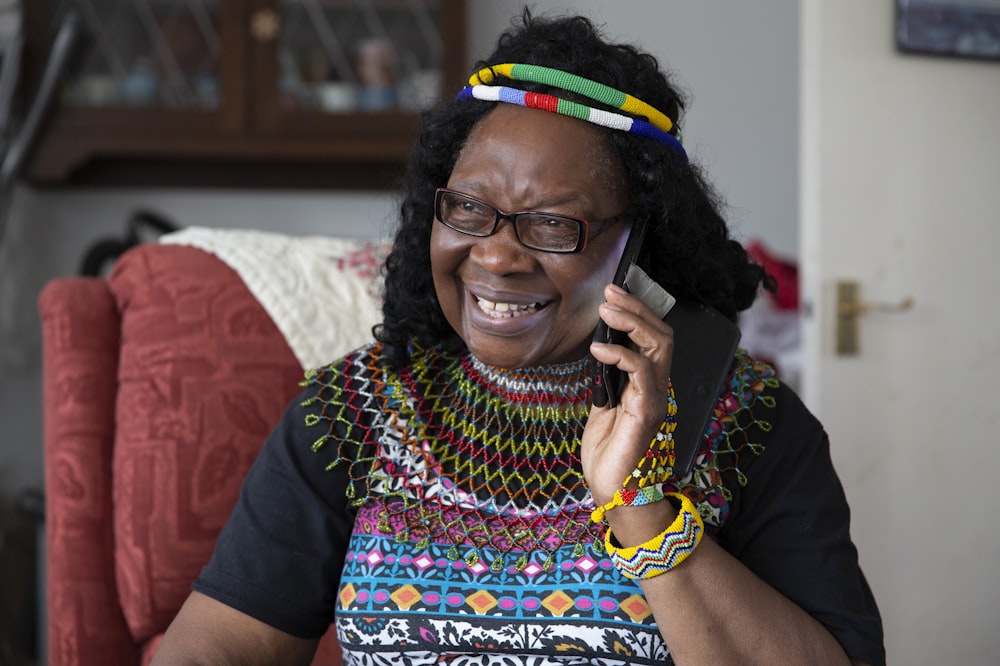 a woman talking on a cell phone wearing a colorful dress